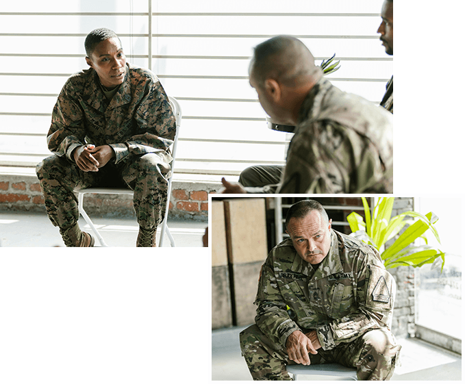 A man in fatigues sitting on the ground.