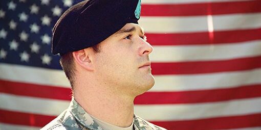 A soldier in uniform looking up at the sky.