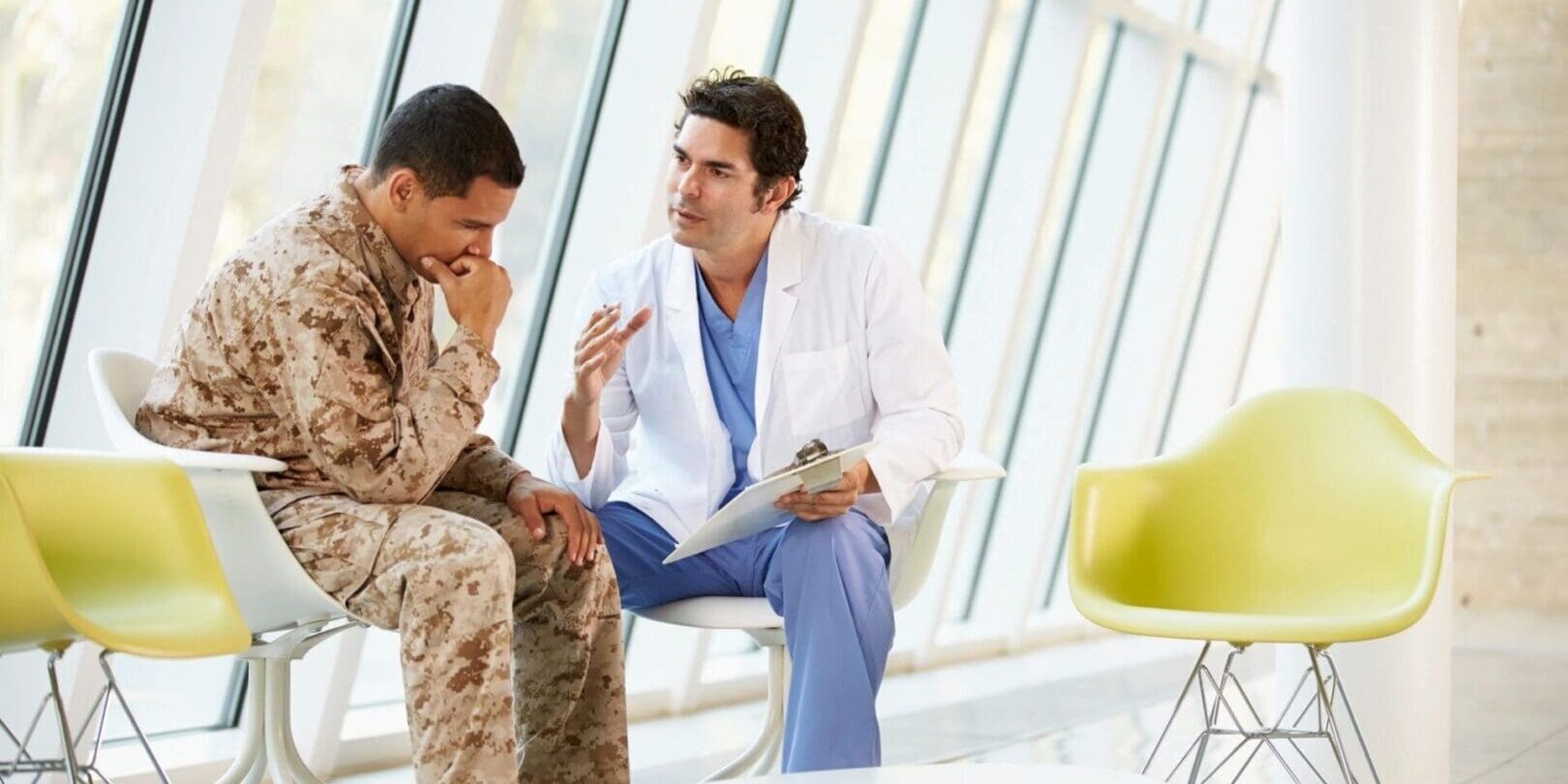 A doctor and soldier are sitting in front of each other.